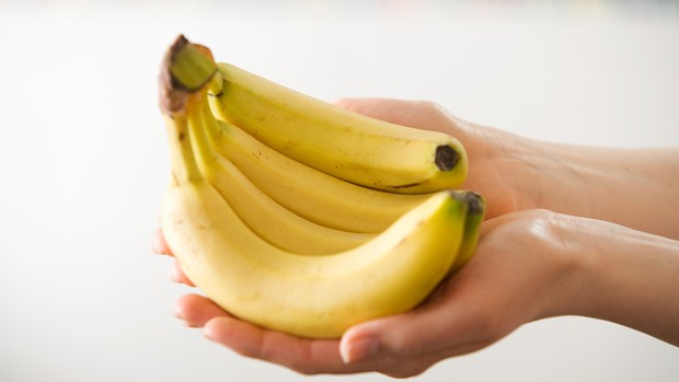 Cacho de Banana nas Mãos de uma Pessoa
